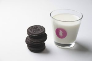 Chocolate sandwich cookies and a glass of milk