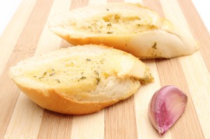 Fresh Baguette With Garlic Butter On Wooden Cutting Board